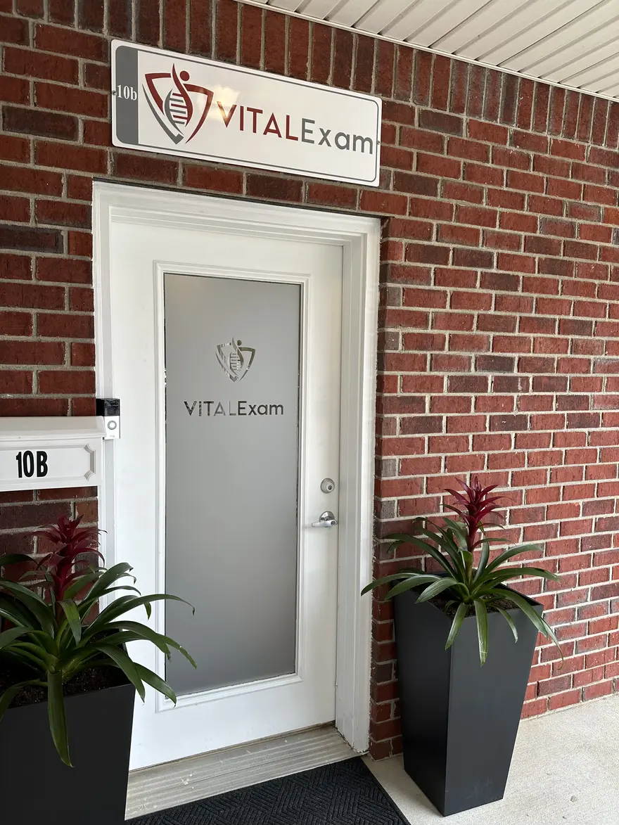 The VITALExam clinic entrance: a white door marked VITALExam beneath a VITALExam sign, at Suite 10B